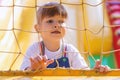 A cute little girl looks through the mesh at a rubber inflatable slide. A child stands on an inflatable trampoline at the weekend.