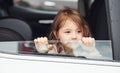 Cute little girl looks through window car. Conception of traveling and vaccation