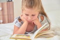 Girl reading lying on bed