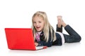 Cute little girl lying down with laptop laughing Royalty Free Stock Photo