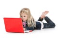 Cute little girl lying down using a laptop Royalty Free Stock Photo