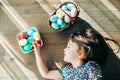 Little girl lying on a floor with Easter eggs in a basket Royalty Free Stock Photo