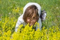 Cute little girl lying in the grass and flowers and laughing Royalty Free Stock Photo