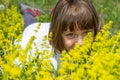 Cute little girl lying in the grass and flowers and laughing Royalty Free Stock Photo