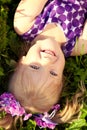 Cute little girl lying on the grass in the park. Smiling nice ch Royalty Free Stock Photo