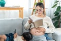 cute little girl Lying on her mother's lap, she was playing with her mobile phone, Asian single mother Sit and read book Royalty Free Stock Photo