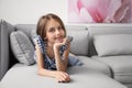 Cute little girl lying on sofa in room Royalty Free Stock Photo