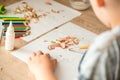 Cute little girl make applique glues colorful house, applying color paper using glue while doing arts and crafts in preschool or h Royalty Free Stock Photo