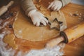 Cute little girl making christmas cookies on messy table, close up. Adorable toddler daughter helping mother and cutting dough for Royalty Free Stock Photo