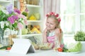 little girl making dinner on kitchen table with tablet at home Royalty Free Stock Photo