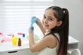 Cute little girl making DIY slime toy at table