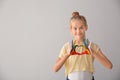 Cute little girl making heart with hands in paint on light background Royalty Free Stock Photo