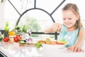 Cute little girl making salad. Child cooking. Healthy food Royalty Free Stock Photo