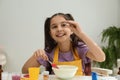 Cute little girl making slime toy at table