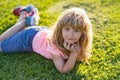 Cute little girl on the meadow in spring day. Happy childhood. Boy lying on grass. Cute kid child enjoying summer on Royalty Free Stock Photo