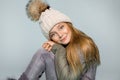 Cute little girl dressed in winter clothes,hat and winter jacket , standing on blue background Royalty Free Stock Photo