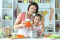 Cute little girl with mother cooking soup together at kitchen table Royalty Free Stock Photo