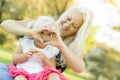 Cute Little Girl With Mother Making Heart Shape with Hands