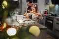 Cute little girl with mother making homemade Christmas gingerbread cookies using rolling pin together in home kitchen.Happy family Royalty Free Stock Photo