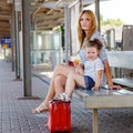 Cute little girl and mother on a railway station. Royalty Free Stock Photo