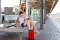 Cute little girl and mother on a railway station. Royalty Free Stock Photo