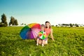 Cute little girl with mother rainbow umbrella holding in the p Royalty Free Stock Photo