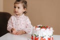 Cute little girl one and a hulf year old stand by delicious birthday cake. Eighteen month old girl verry happy and Royalty Free Stock Photo