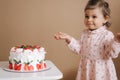 Cute little girl one and a hulf year old stand by delicious birthday cake. Eighteen month old girl verry happy and Royalty Free Stock Photo