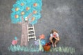 Cute little girl painting with colorful chalks apples harvest from apple tree on asphalt. Cute preschool child with Royalty Free Stock Photo