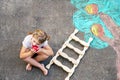 Cute little girl painting with colorful chalks apples harvest from apple tree on asphalt. Cute preschool child with Royalty Free Stock Photo