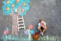 Cute little girl painting with colorful chalks apples harvest from apple tree on asphalt. Cute preschool child with Royalty Free Stock Photo