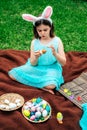 Cute little girl is painting Easter egg with her finger Royalty Free Stock Photo
