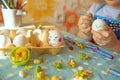 Cute little girl is painting eggs for Easter. girl draws cute faces on Easter eggs