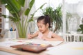 Cute little girl painting picture on home interior background Royalty Free Stock Photo