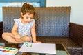 Cute little girl painting picture on home interior background. Summer fun. Royalty Free Stock Photo