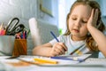 Cute little girl paints picture with colored pencils. child draws coloring book Royalty Free Stock Photo