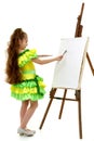 Little girl with a palette and brush near the easel.