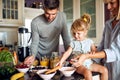 Cute little girl with parents preparing breakfast