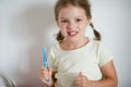 Cute little girl with pigtails diligently brushing his teeth.