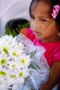 Cute little girl in pink dress holding white flowers bouquet on wedding celebration. Little flower girl at wedding Royalty Free Stock Photo