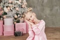 Cute little girl in pink dress with present on background Christmas tree. Merry Christmas and Happy Holidays! Baby healthy and Royalty Free Stock Photo
