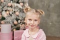 Cute little girl in pink dress with present on background Christmas tree. Merry Christmas and Happy Holidays! Baby healthy and Royalty Free Stock Photo