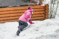 Cute little girl in pink sport suit having fun playing outdoors during snowfall in winter. Children winter seasonal outdoor Royalty Free Stock Photo