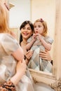 a cute little girl in a plaid dress and mom primping.