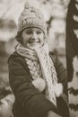 A cute little girl on a playground in autumn. Monochrome photo.