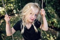 Cute little girl playing alone on a swing outside Royalty Free Stock Photo