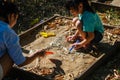 Cute little girl playing as a little archaeologist with her mother digging dinosaur fossils in the playground. Children learning Royalty Free Stock Photo