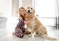 Cute little girl playing with beautiful goden retriever dog