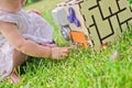 Cute little girl is playing with busiboard outdoors on green grass. Educational toy for toddlers. girl opened door to cube of