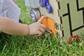 Cute little girl is playing with busiboard outdoors on green grass. Educational toy for toddlers. girl opened door to cube of Royalty Free Stock Photo